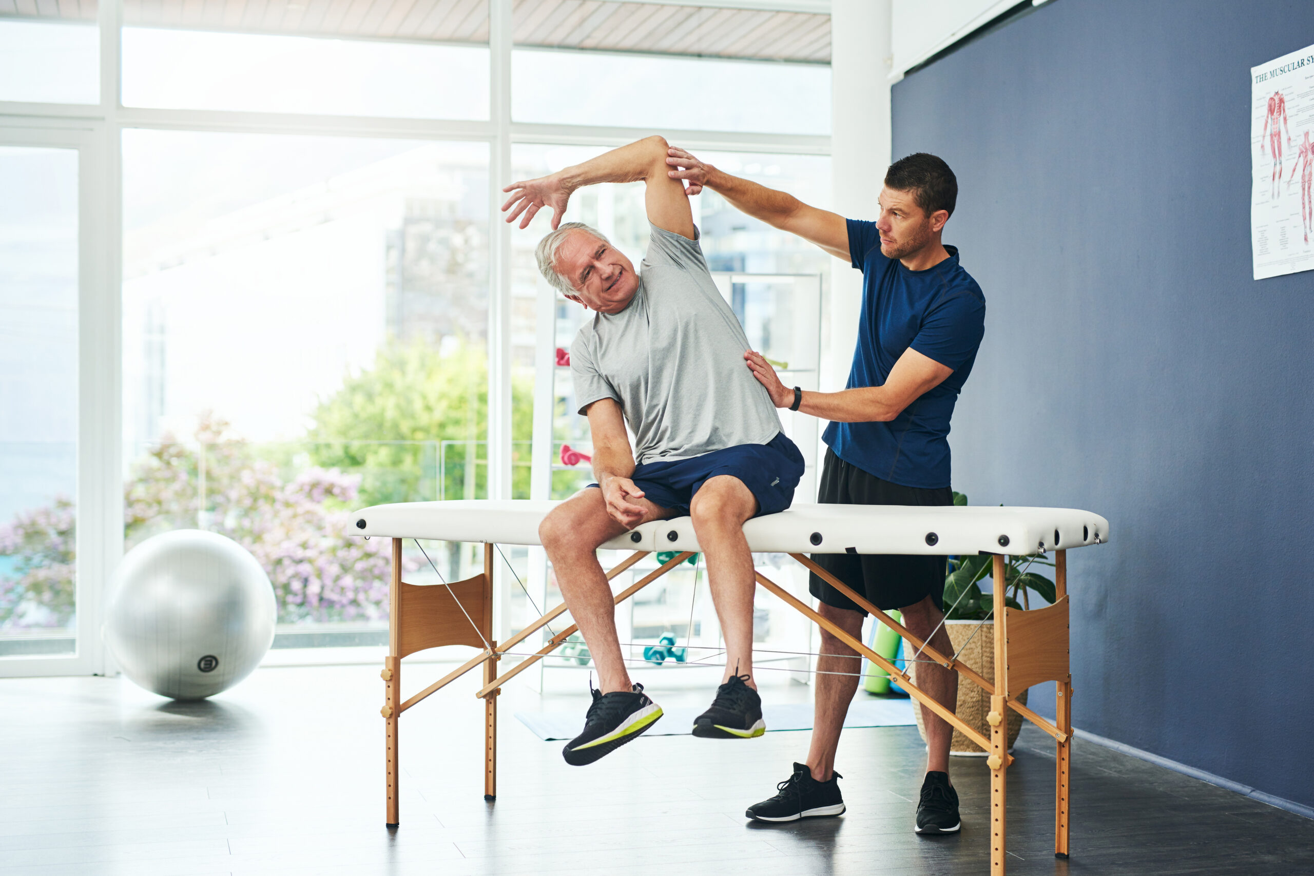 Fisioterapeuta del extranjero tratando a una paciente en una clínica moderna en Alemania – iniciar carrera como fisioterapeuta en Alemania